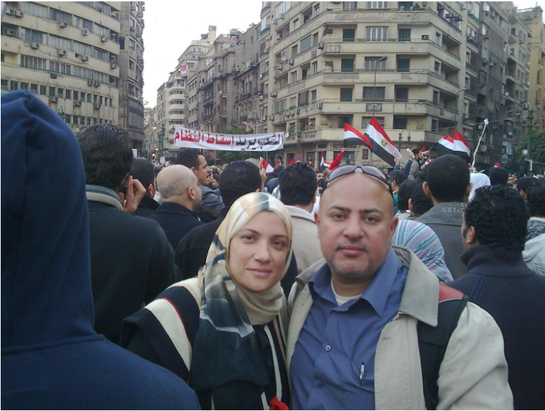 My parents in the 2011 Egyptian revolution, sign in the back says the people want the downfall of the regime in Arabic. 
